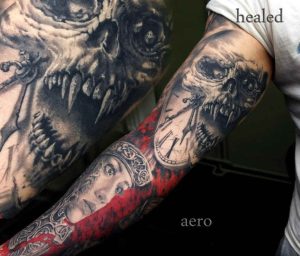 Geheiltes Tattoo auf dem Unterarm – detailreiches Realistic-Motiv mit Schädel, Uhr und Porträt, gestochen in Schwarz, Grau und Rot