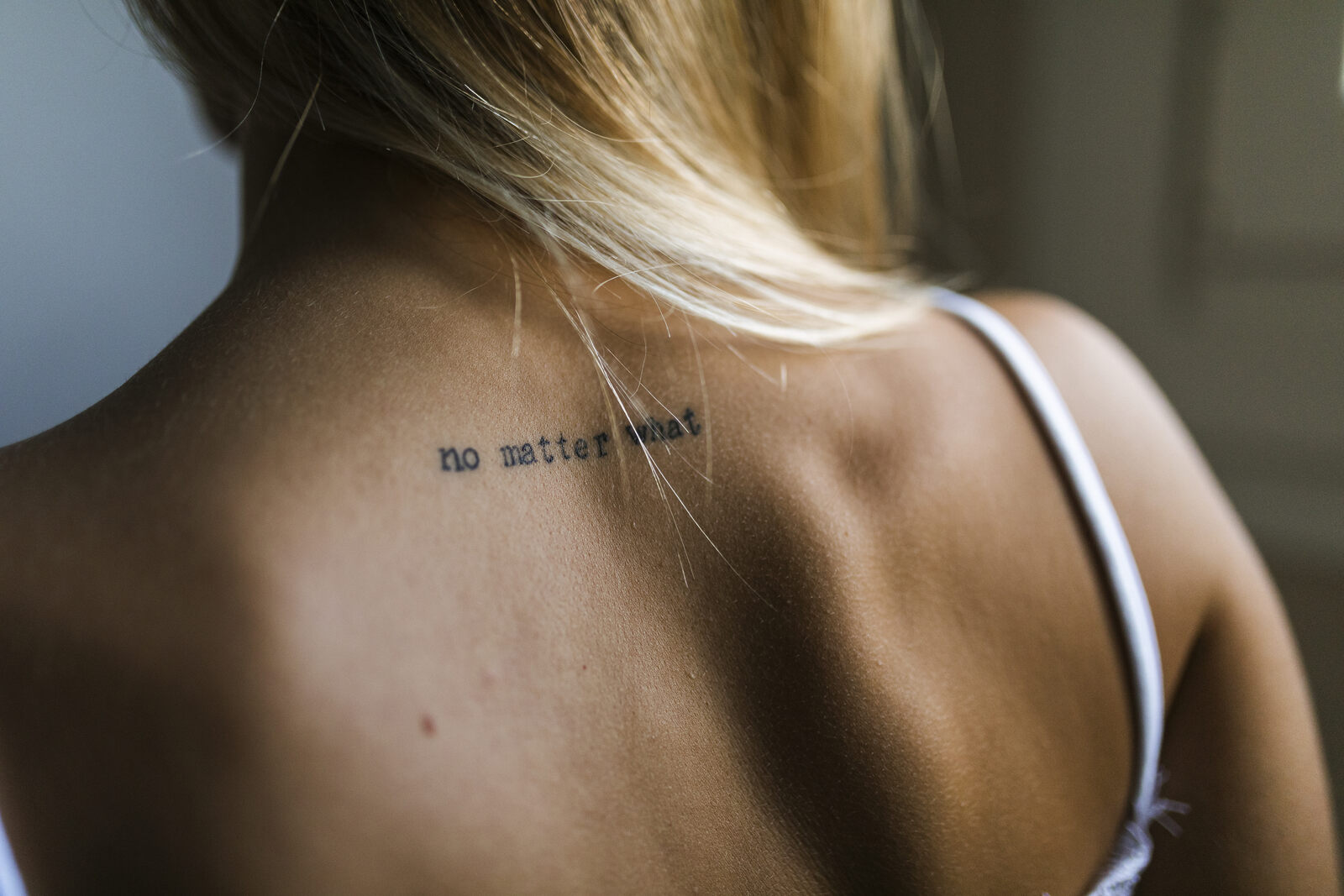Rücken mit verblasstem Schriftzug während der Vorbereitung für ein neues Tattoo